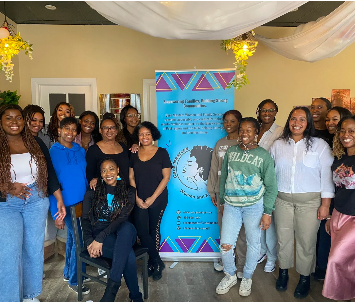 Care Masters team and community members gathered around the organization’s banner